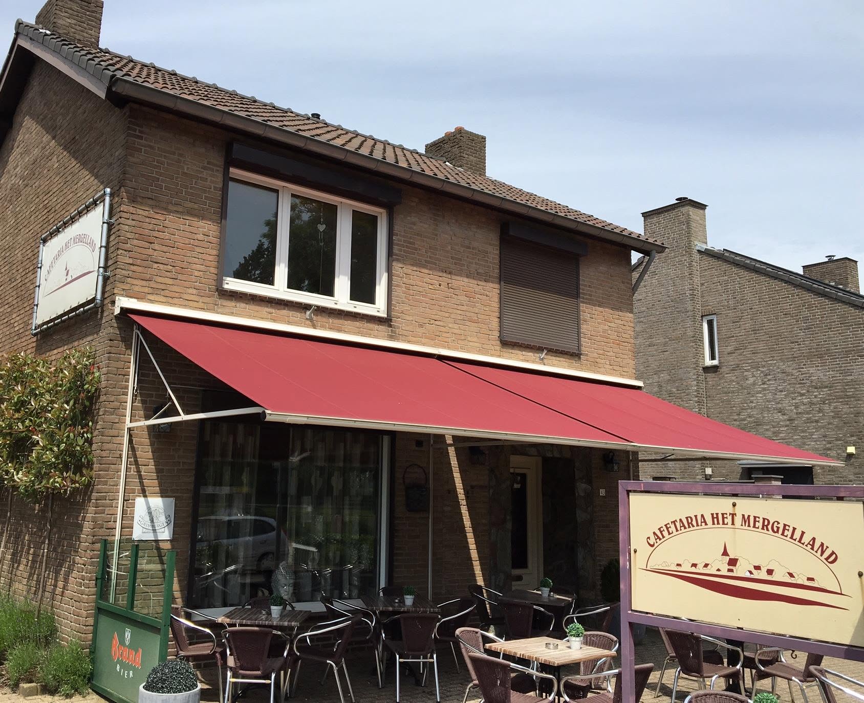 Rood uitstaand zonnescherm boven een terras met tafels en stoelen
