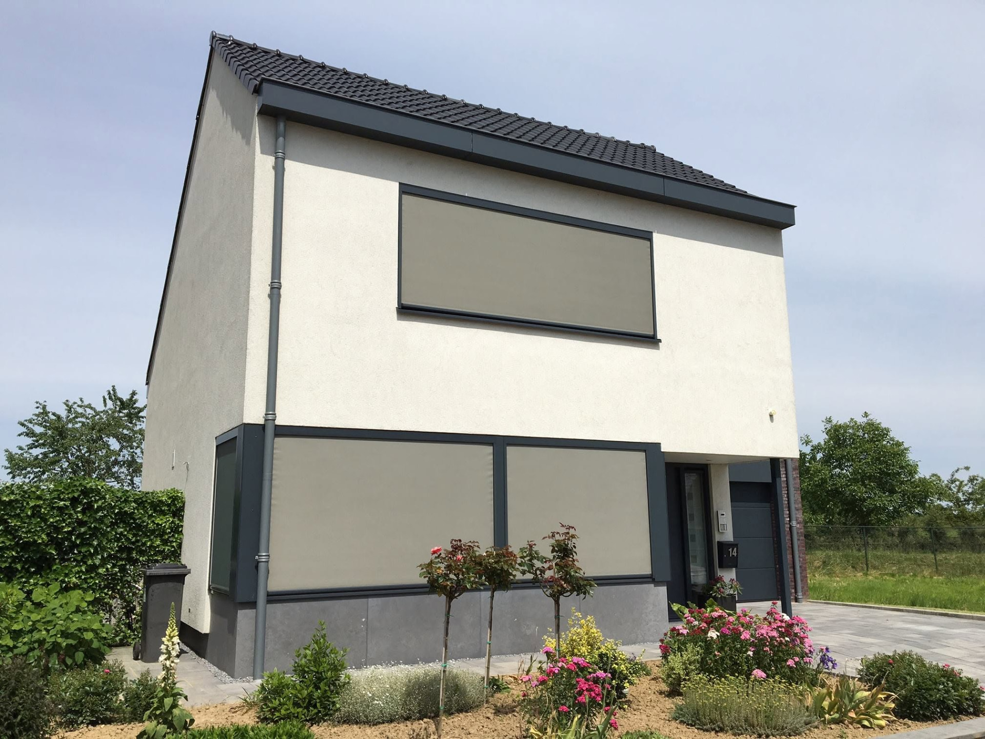 Woning met screens voor de ramen op de eerste en tweede verdieping